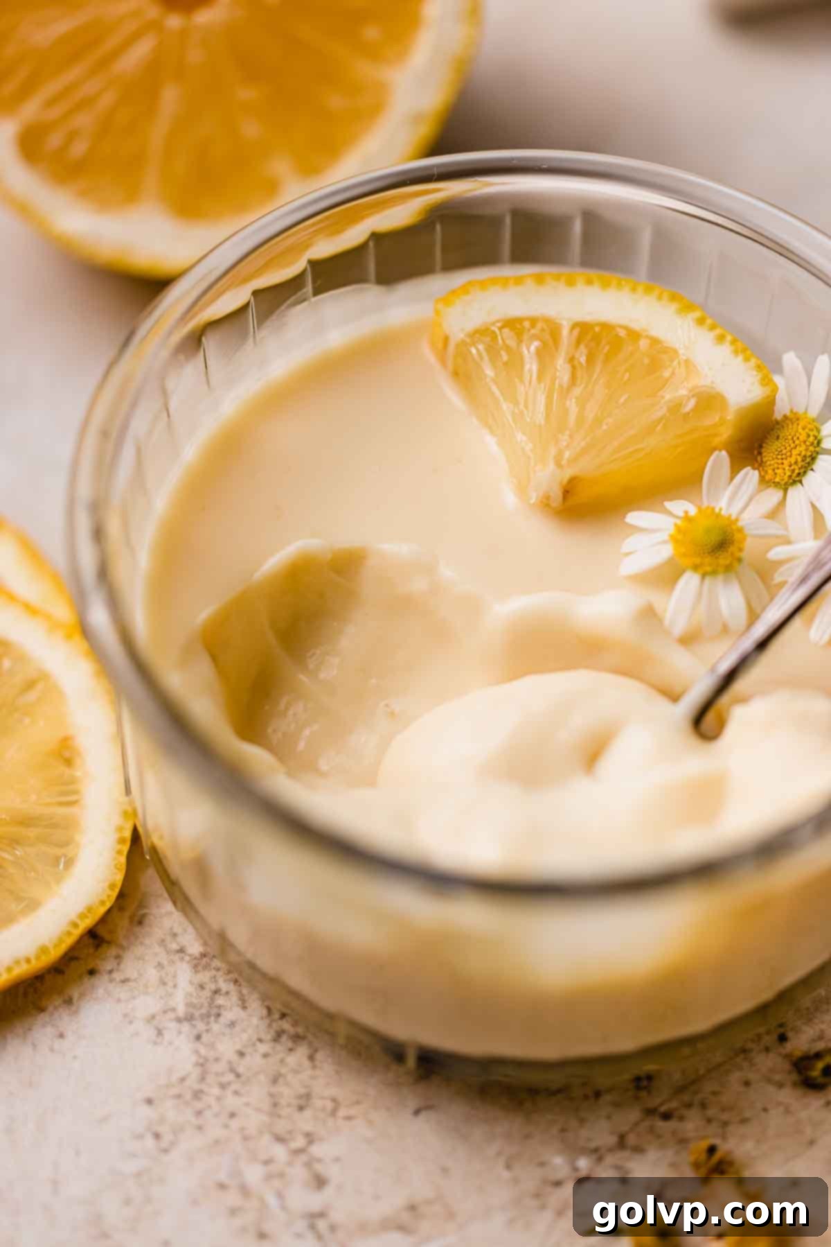 Close-up of the thick, velvety texture of lemon posset in a ramekin, showcasing its richness.