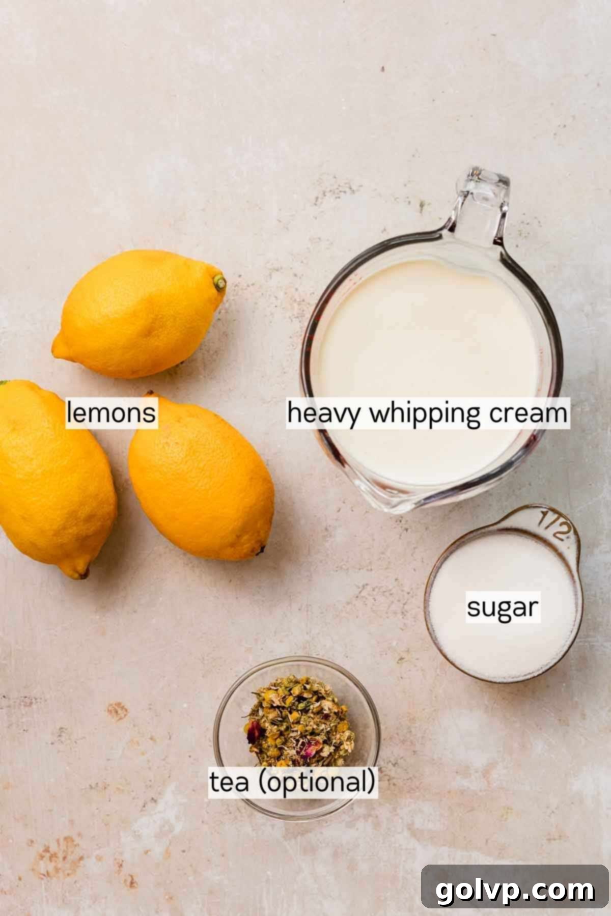 Bowls of fresh lemons, tea leaves, heavy cream, and sugar, laid out as key ingredients for lemon posset.