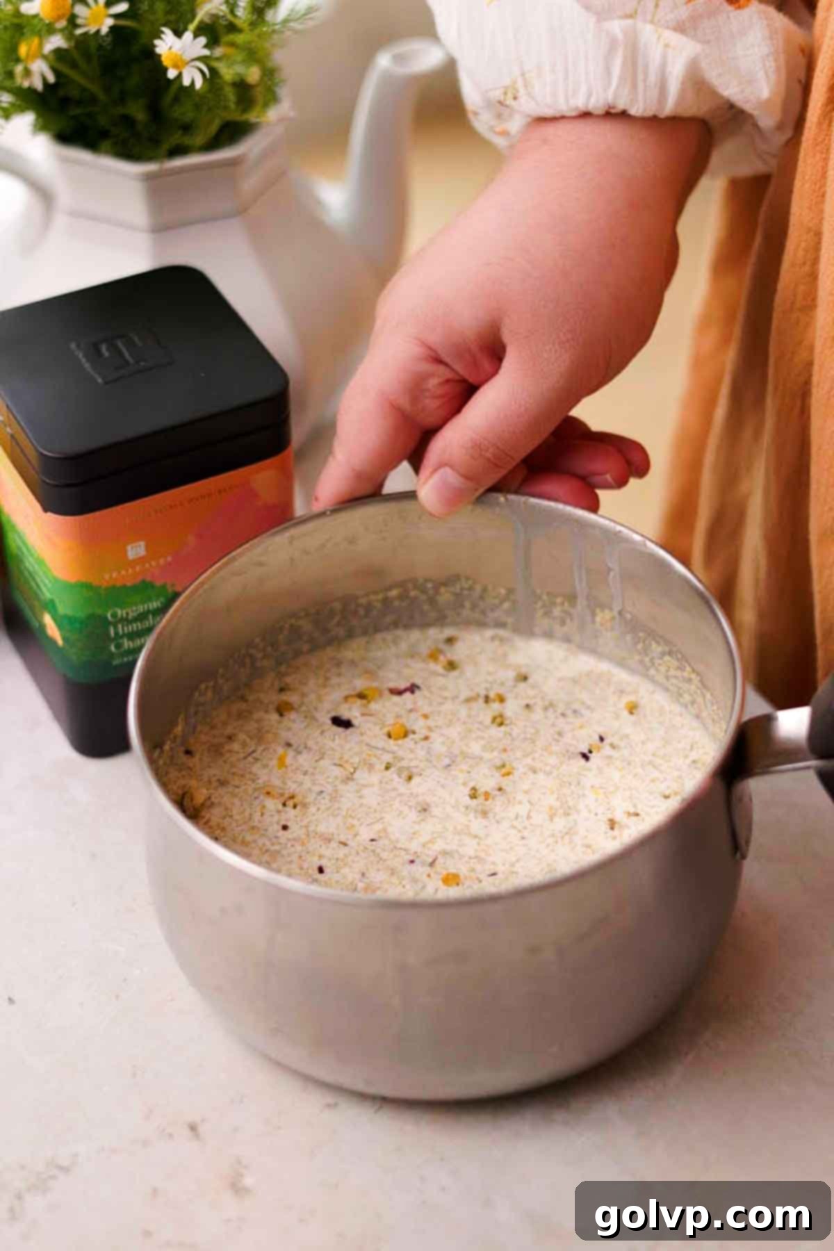 Lemon posset ingredients, including cream, sugar, lemon zest, and tea, ready to be cooked in a saucepan.