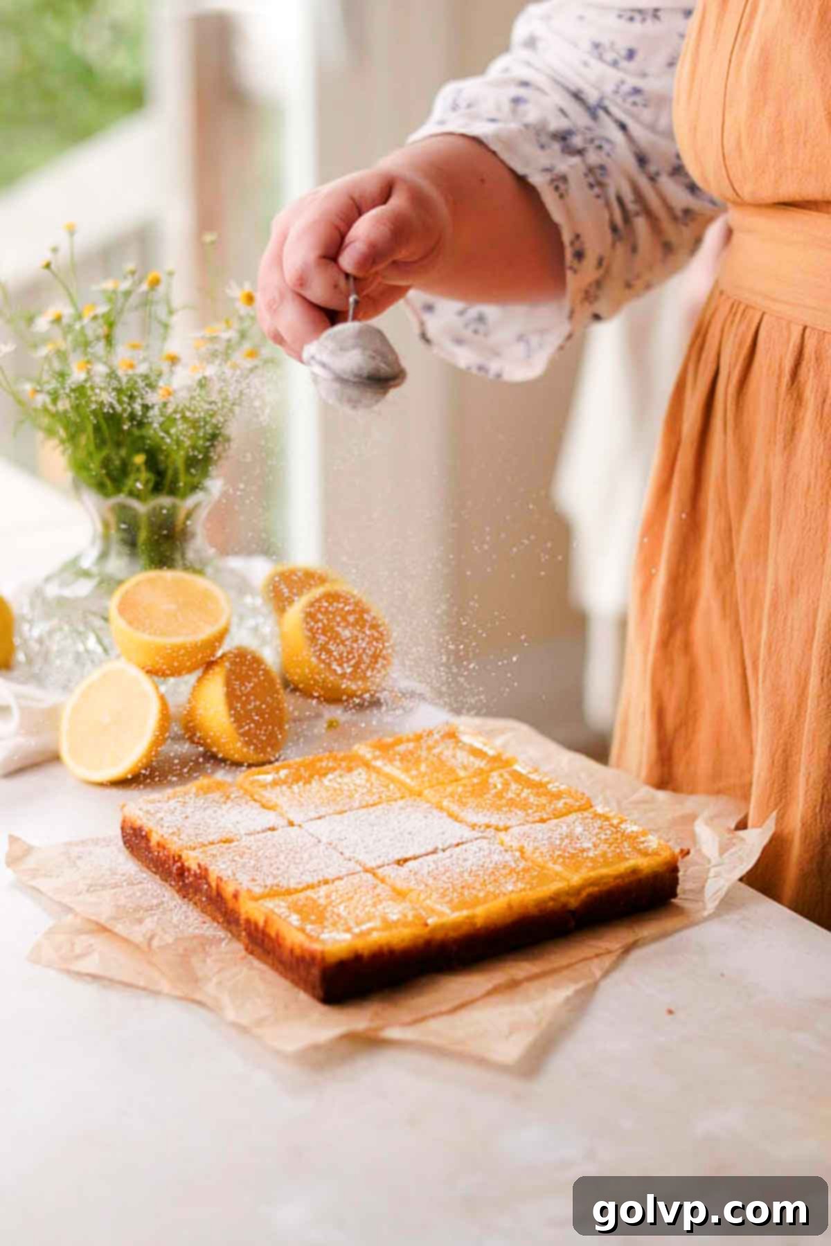 dusting lemon bars with powdered sugar