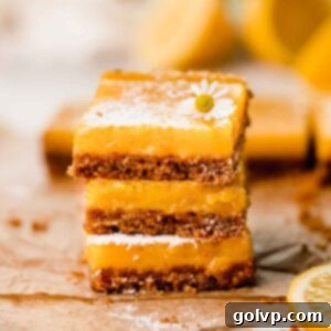 stacked lemon bars with graham cracker crust and powdered sugar