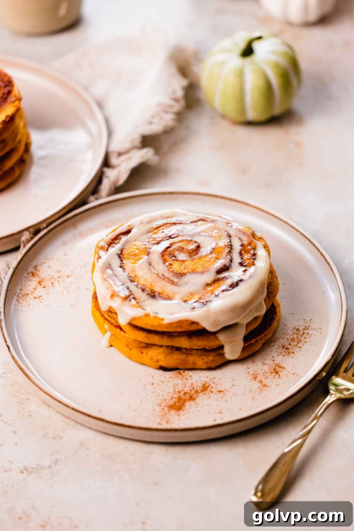 Fluffy pumpkin spice pancakes with cinnamon roll swirl and cream cheese glaze