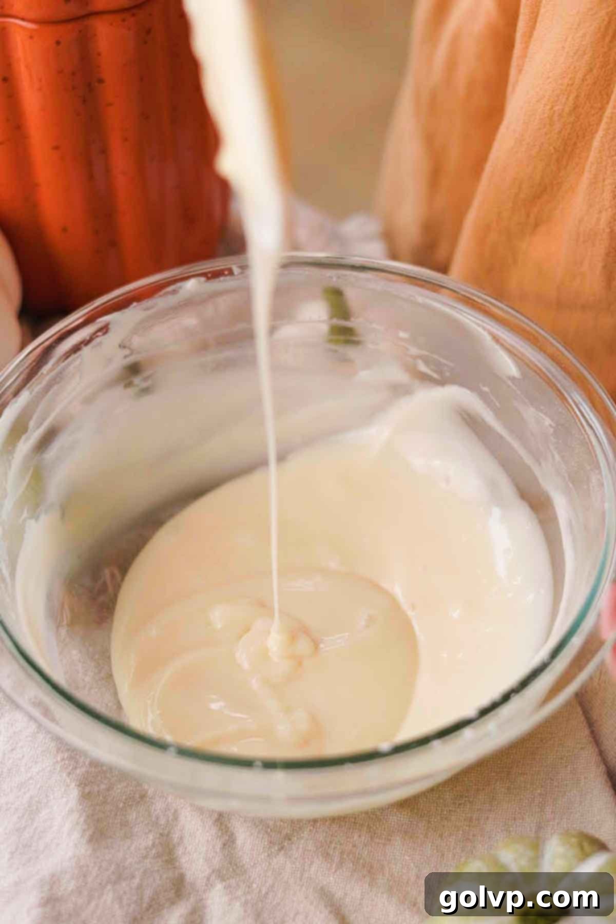 Step 2: Adding milk to cream cheese glaze for desired consistency
