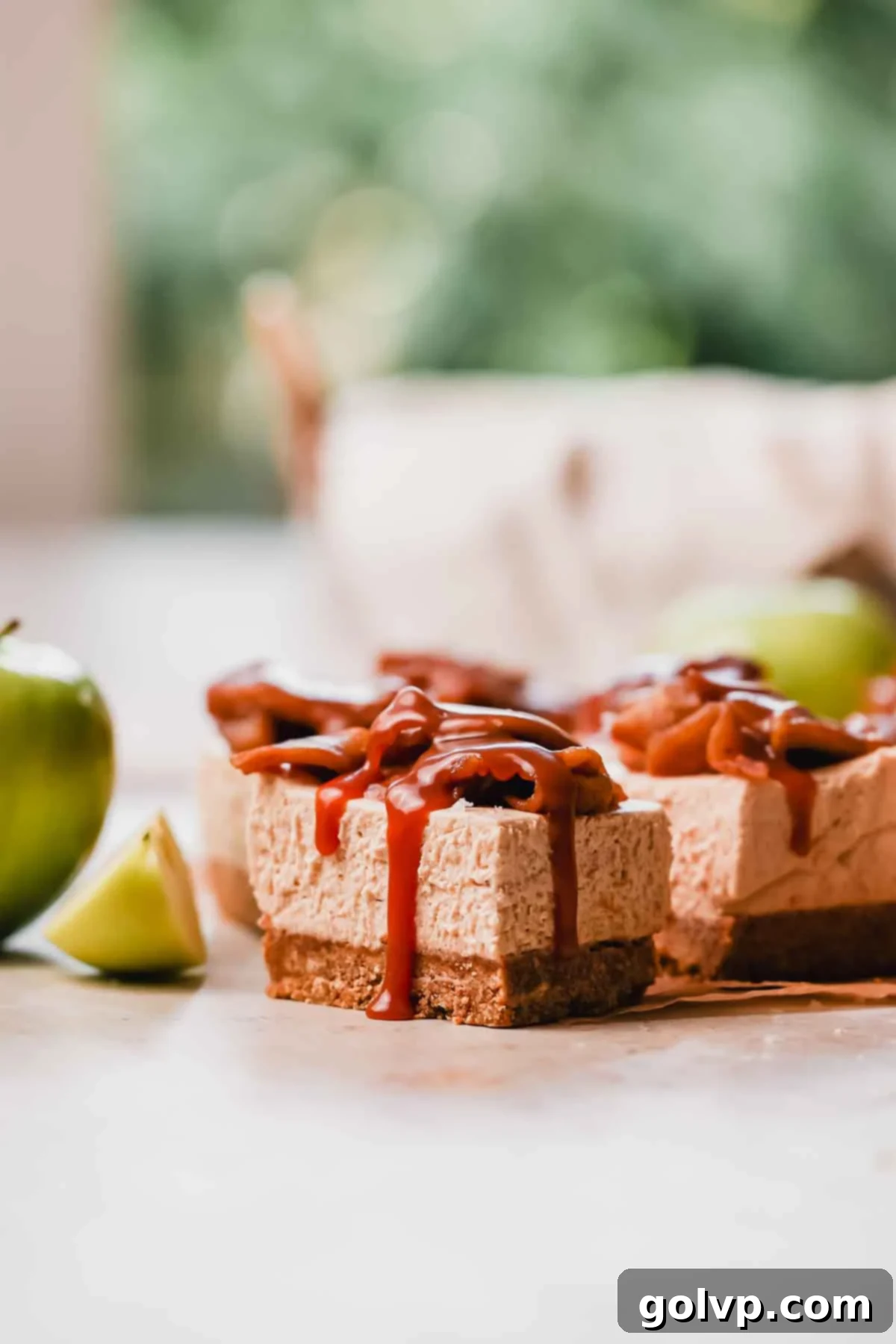 side view of caramel apple cheesecake bars with caramel running down the side