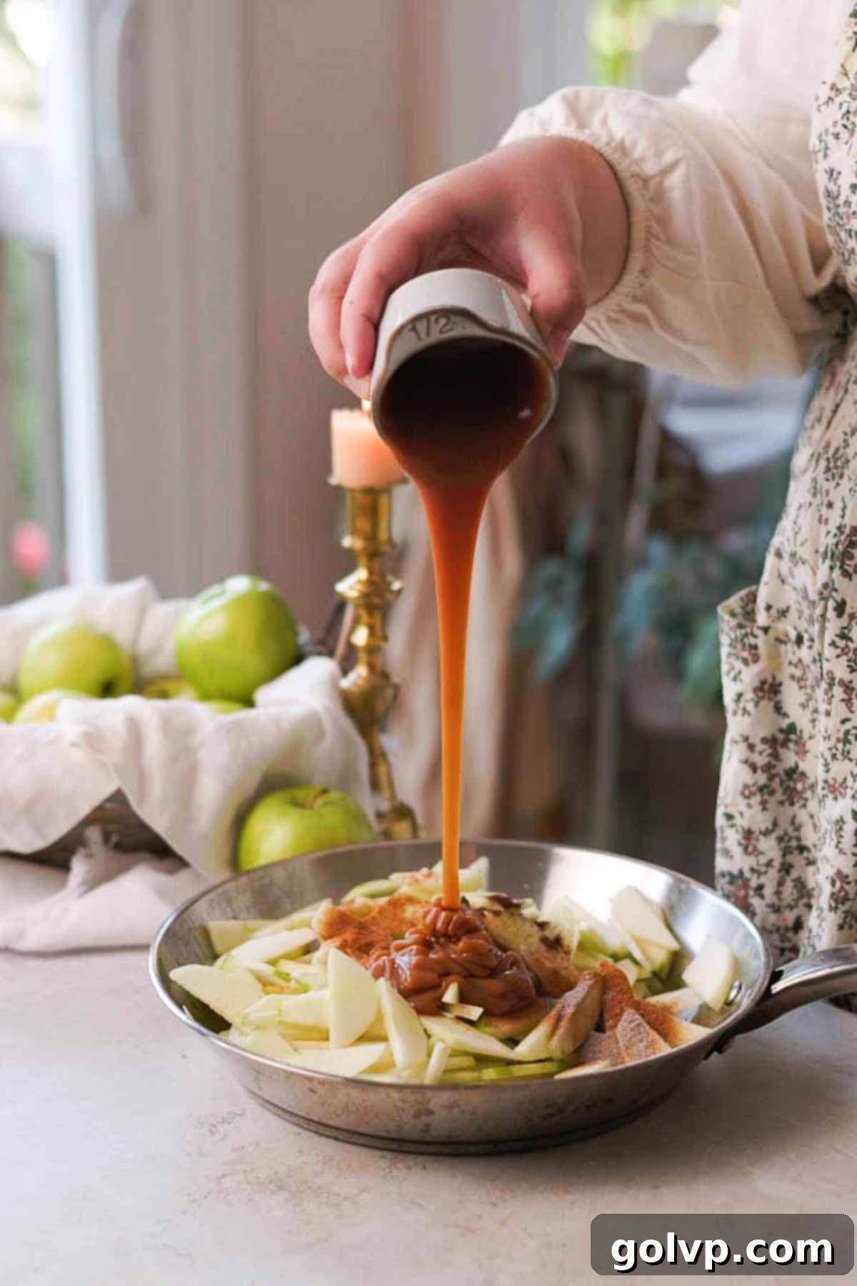 caramel being poured over apple filling ingredients directly in pan