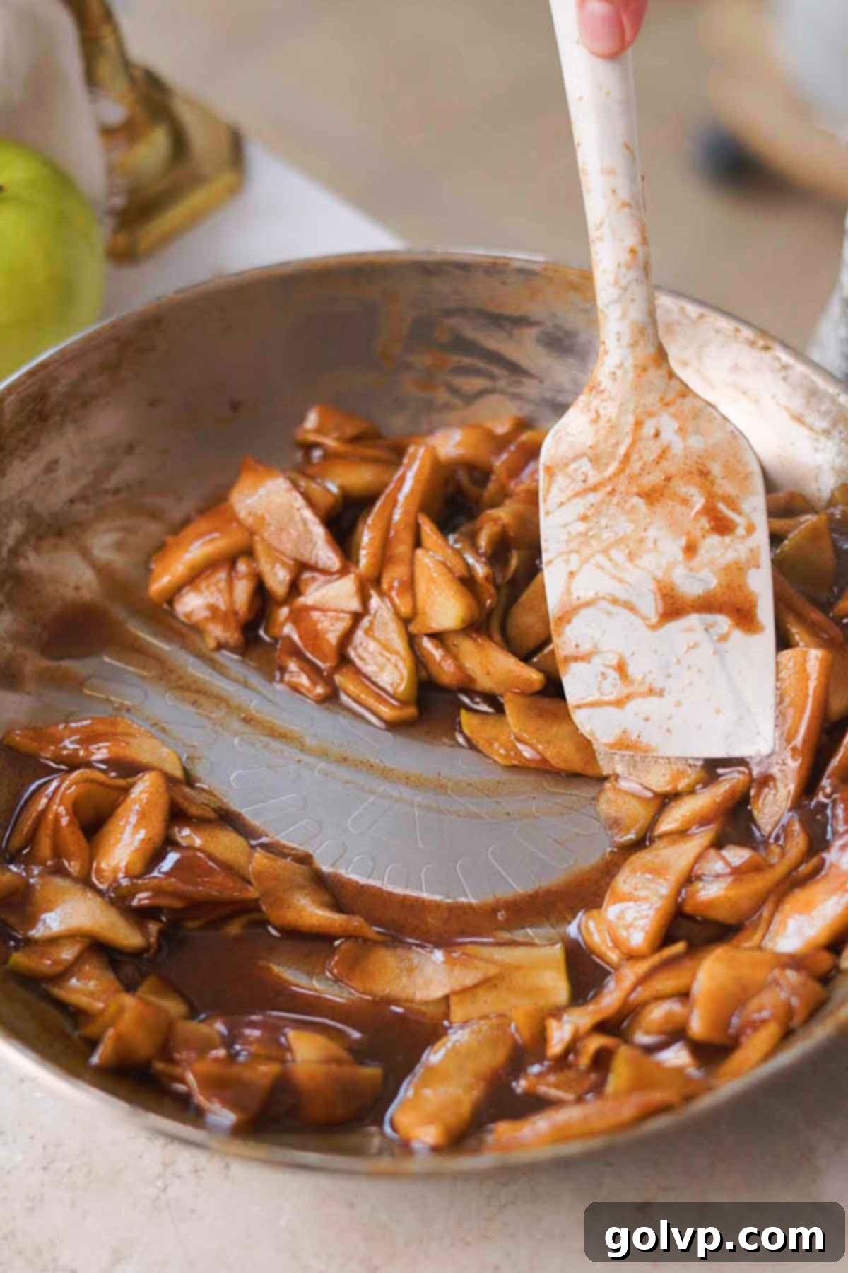 stirring cooked caramel apple topping in the pan