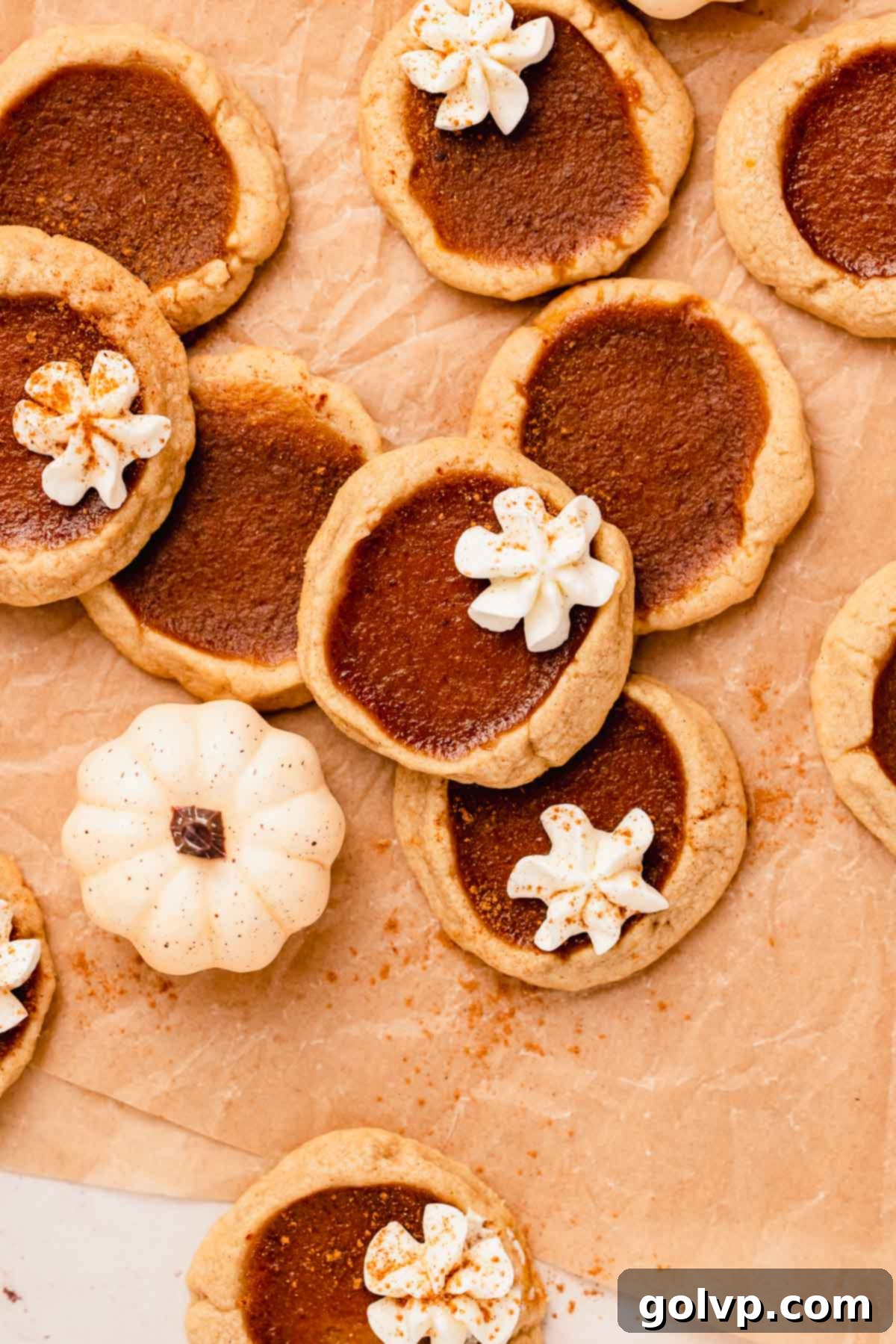 Freshly baked pumpkin pie cookies with whipped cream topping, perfect for fall and Thanksgiving.
