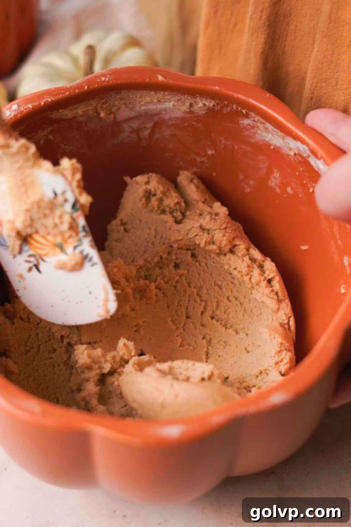 Sifting and folding flour into the creamy egg and butter mixture for cookie dough.