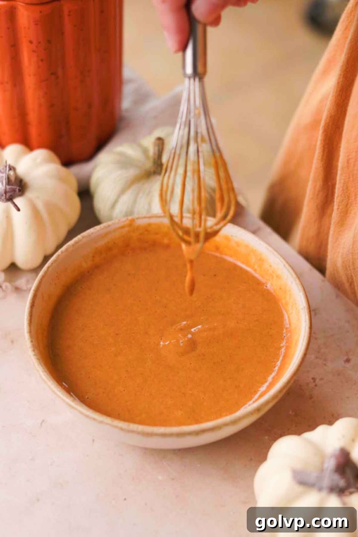 Mixing pumpkin purée, cornstarch, salt, pumpkin spice, and evaporated milk into the egg mixture.