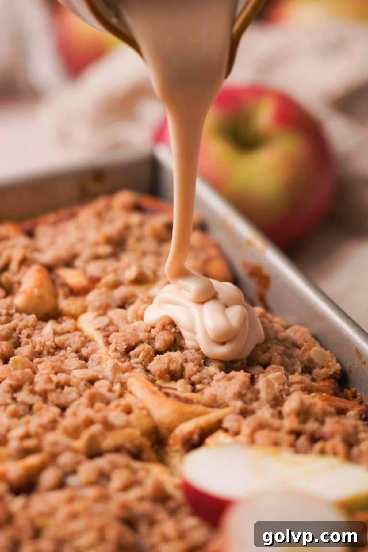 Generously drizzling creamy salted caramel cream cheese glaze over freshly baked apple cinnamon rolls for a decadent finish.