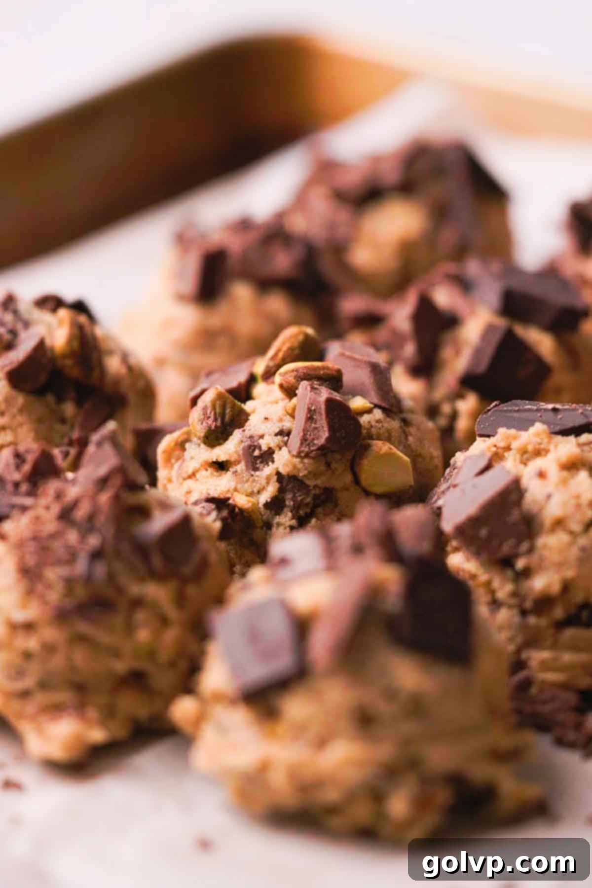 scooped pistachio brown butter chocolate chip cookie dough topped with chocolate and pistachio pieces