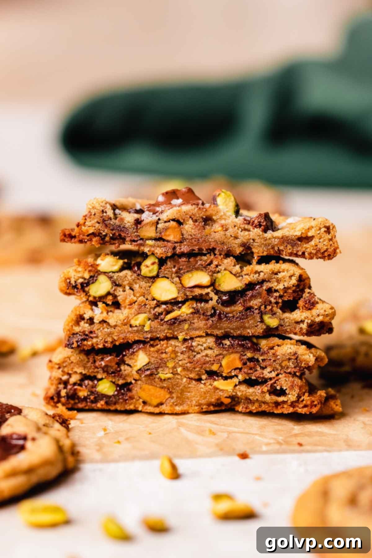 stack of cookies with pistachios and chocolate cut in half to show center