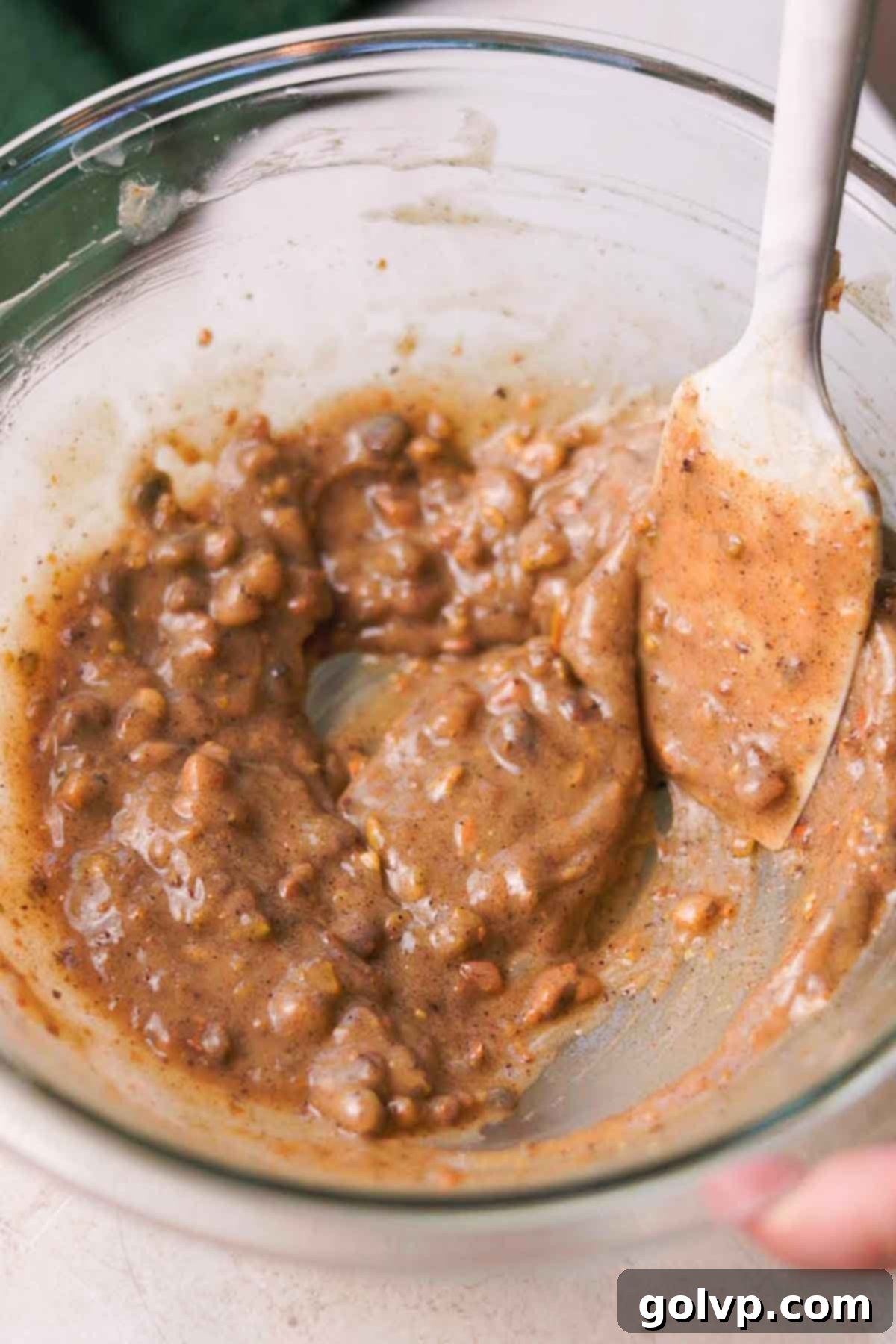 Stirring cooled brown butter with pistachios with spatula