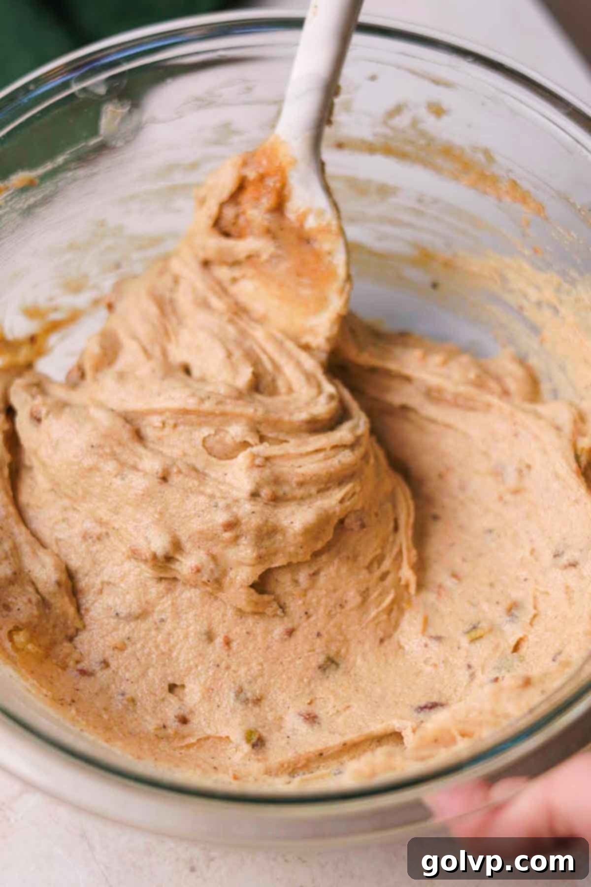 stirring wet ingredients for pistachio chocolate chip cookies in a large glass bowl