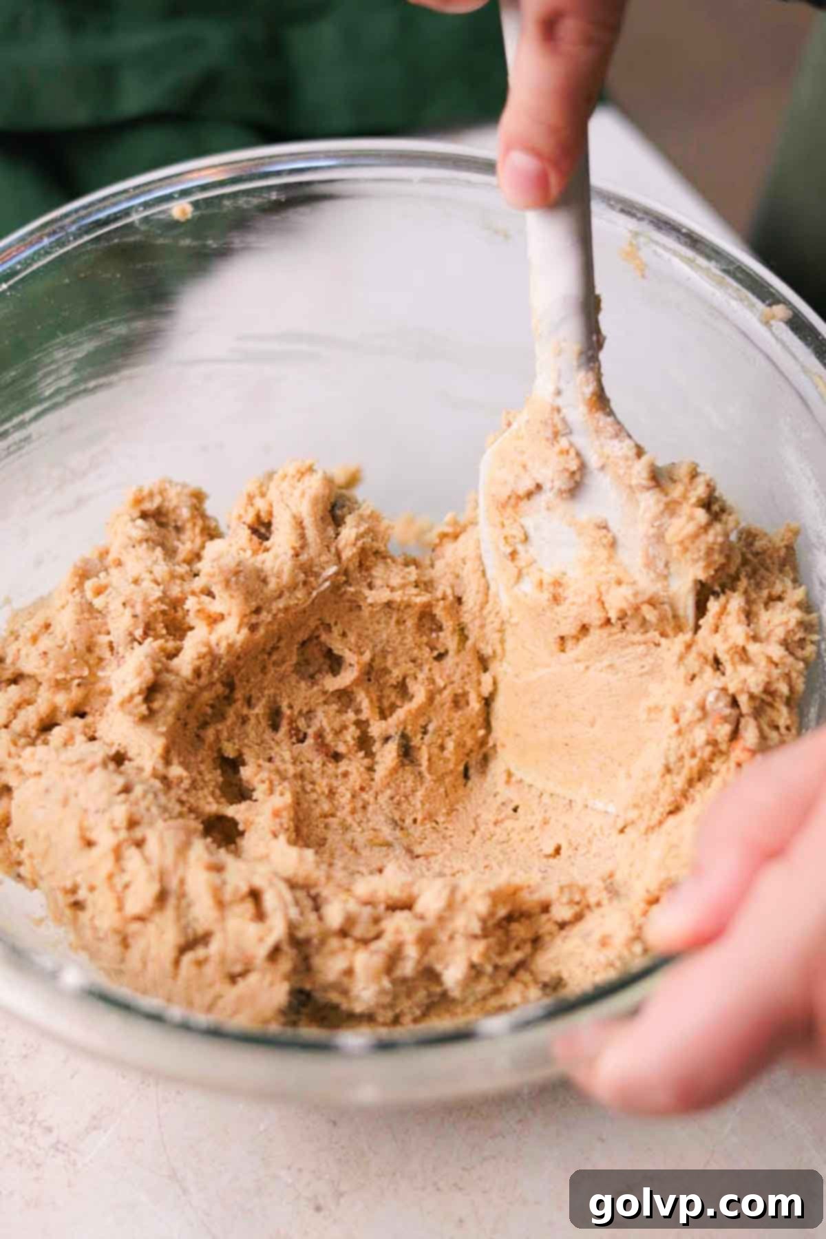 folding pistachio cookie dough with a spatula