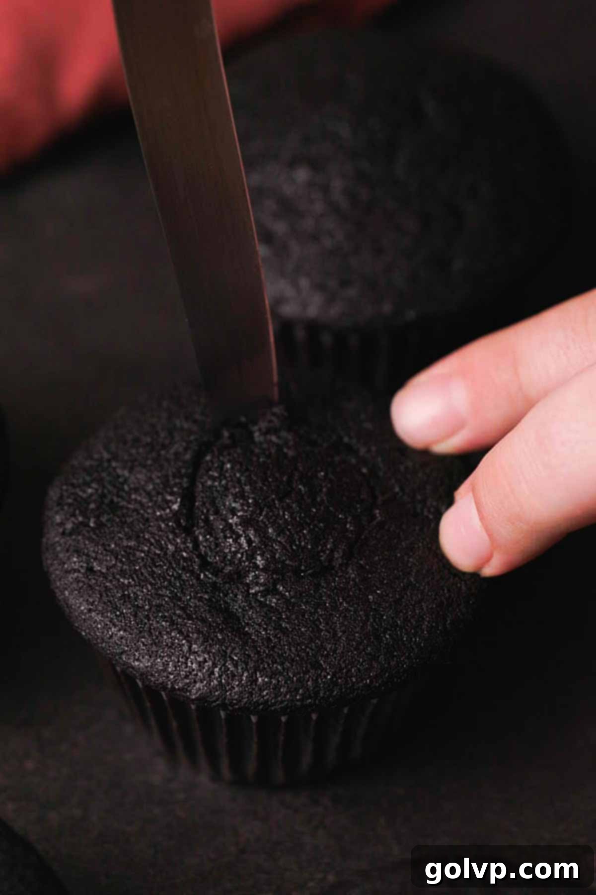 removing center from a black velvet cupcake to add filling