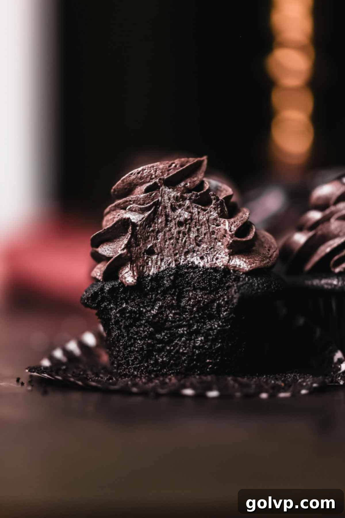 bitten black velvet cupcake showing cherry filling and dark crumb
