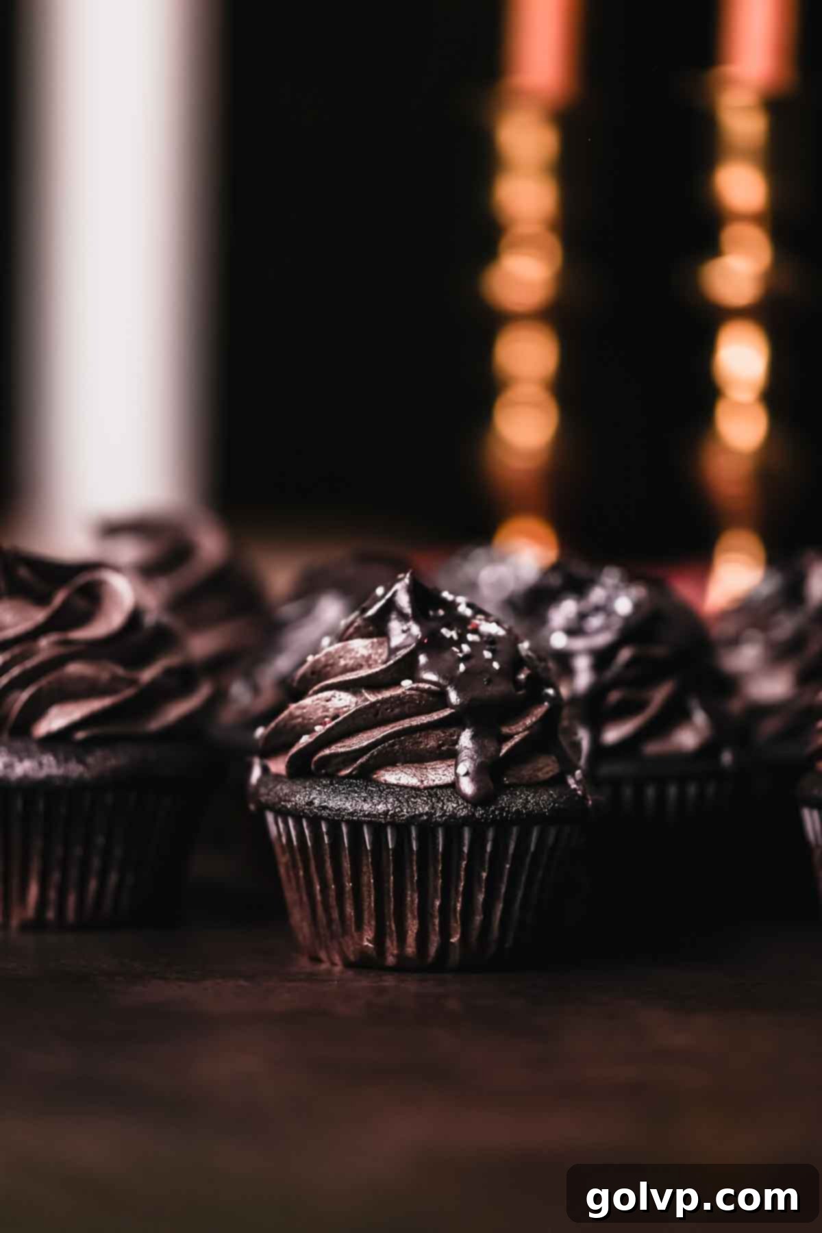 black velvet cupcake with chocolate drip and sprinkles