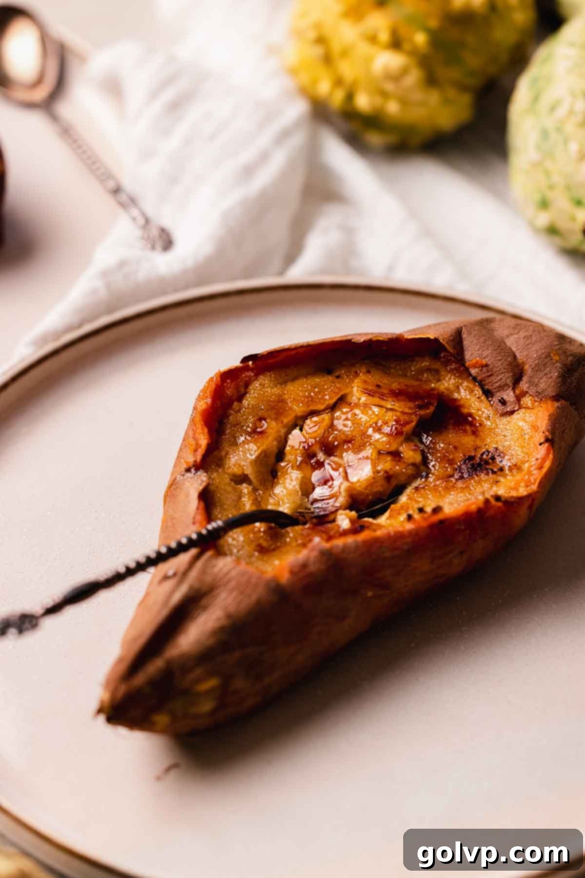 A sweet potato crème brûlée with its top cracked, revealing the creamy custard, ready to be eaten.