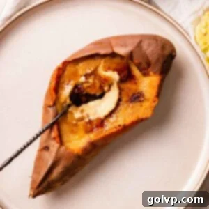 Spoon breaking the crunchy top of a sweet potato crème brûlée, revealing the smooth custard.