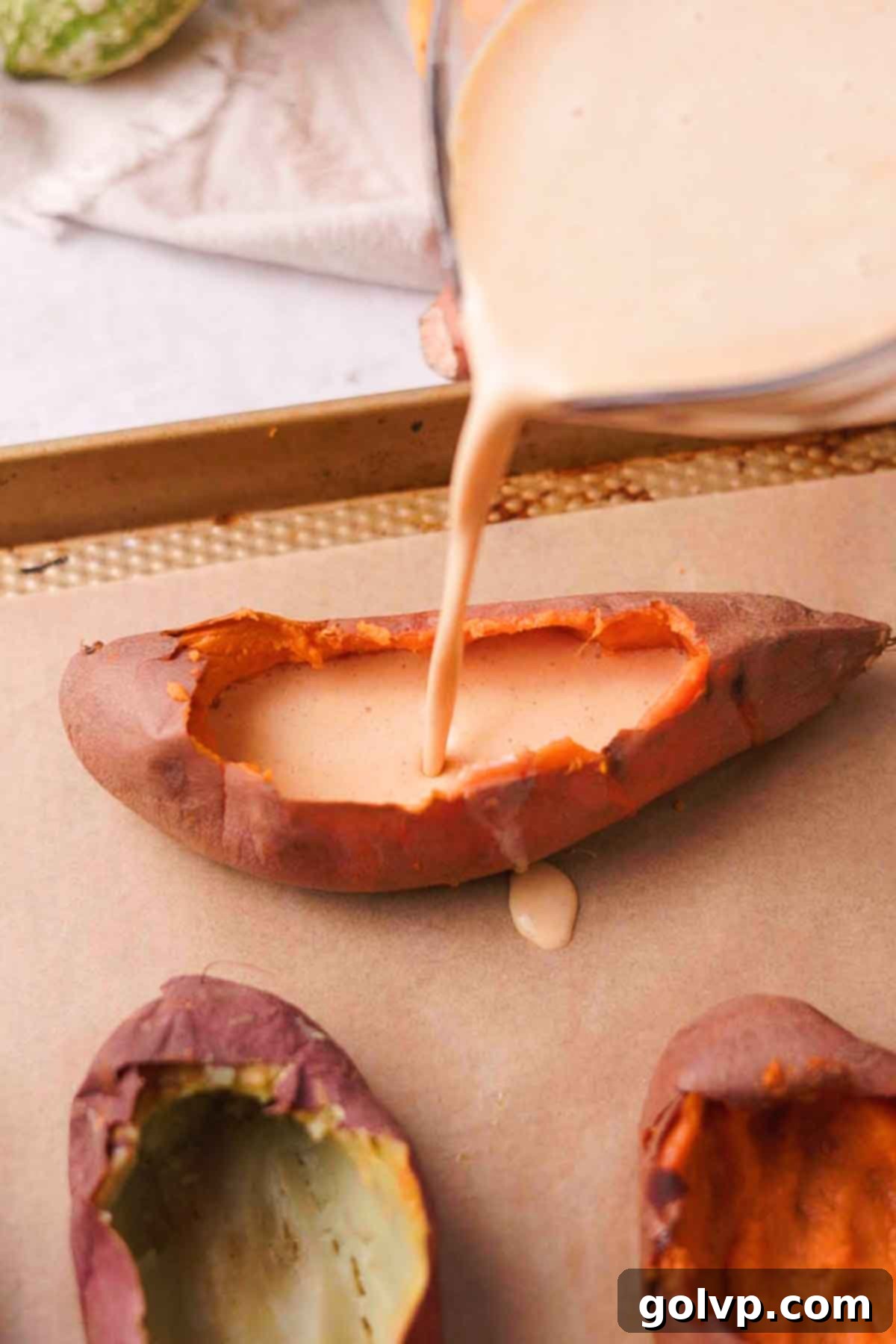 The sweet potato crème brûlée mixture being poured carefully into hollowed sweet potatoes.