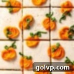 A beautifully sliced pumpkin cake topped with white cream cheese frosting and charming piped mini pumpkins, showcasing its festive design.