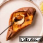 Spoon cracking through the perfectly crunchy caramelized sugar topping of a sweet potato crème brûlée, revealing the smooth, creamy custard beneath.