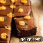 A delightful chocolate cake generously frosted and decorated with charming piped mini pumpkins, perfect for a fall celebration.