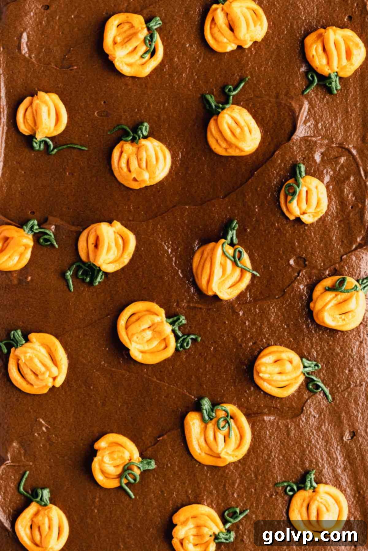 Close-up of exquisitely piped mini buttercream pumpkins adorning the top of a chocolate pumpkin cake, adding a festive and charming touch to the holiday dessert.