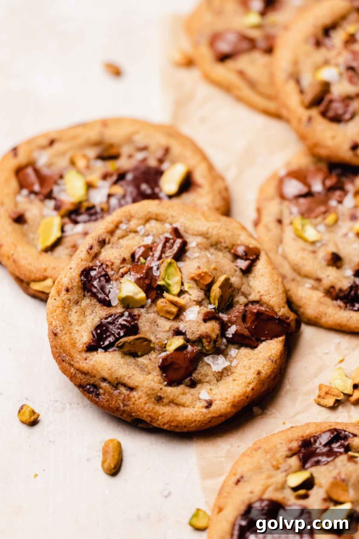 A beautifully baked pistachio chocolate chip cookie, generously studded with chunks of chocolate and vibrant green pistachios, showcasing its inviting texture.