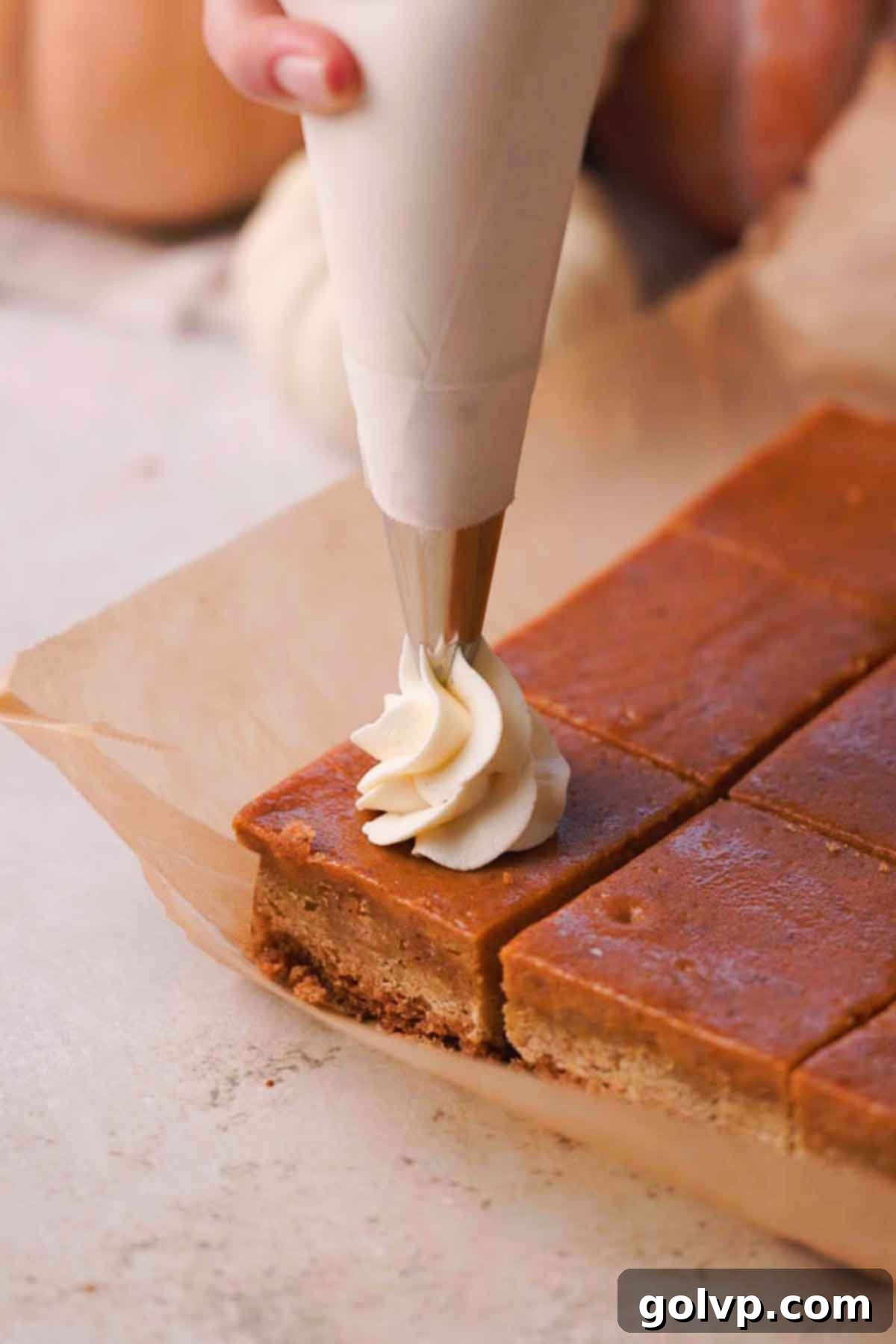 piping whipped cream onto pumpkin pie bars