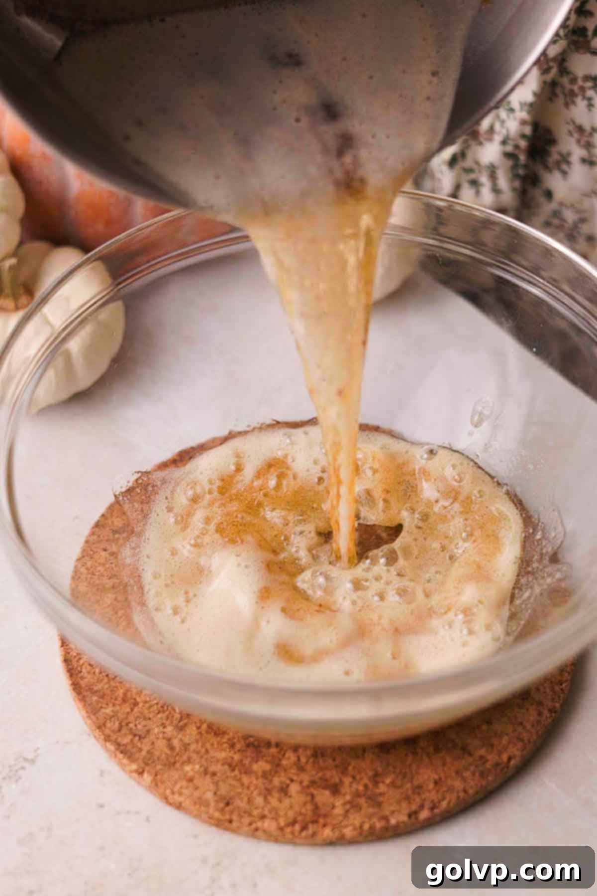 pouring browned butter into a mixing bowl