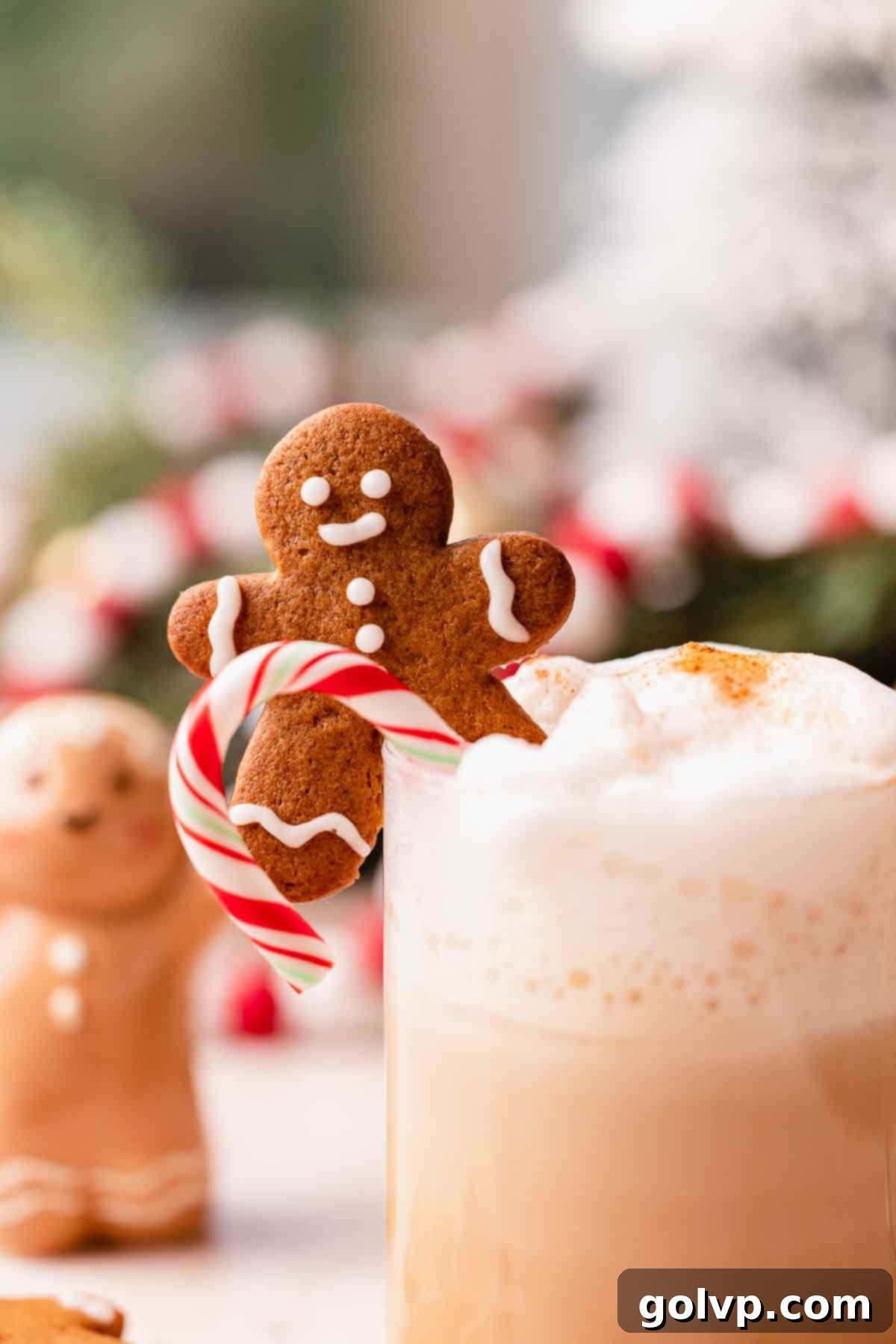 Close-up of a gingerbread man cookie garnish on a creamy gingerbread latte, showcasing holiday cheer