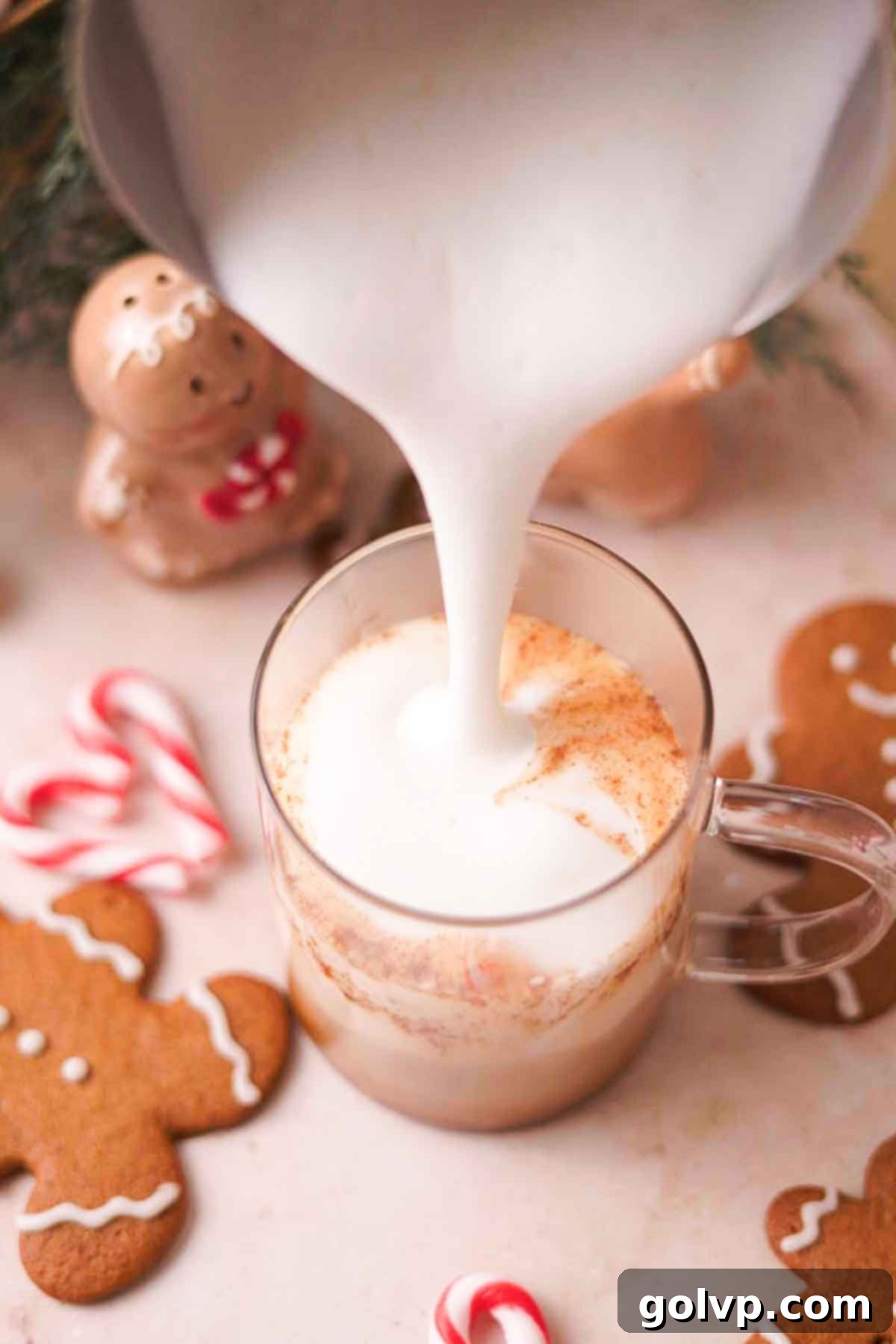 Pouring freshly steamed milk into a mug with gingerbread latte mixture