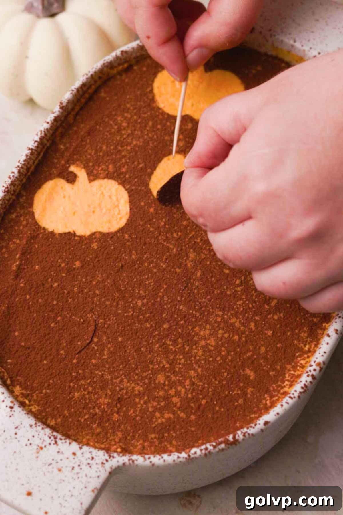 Removing pumpkin decals after dusting cocoa powder on tiramisu