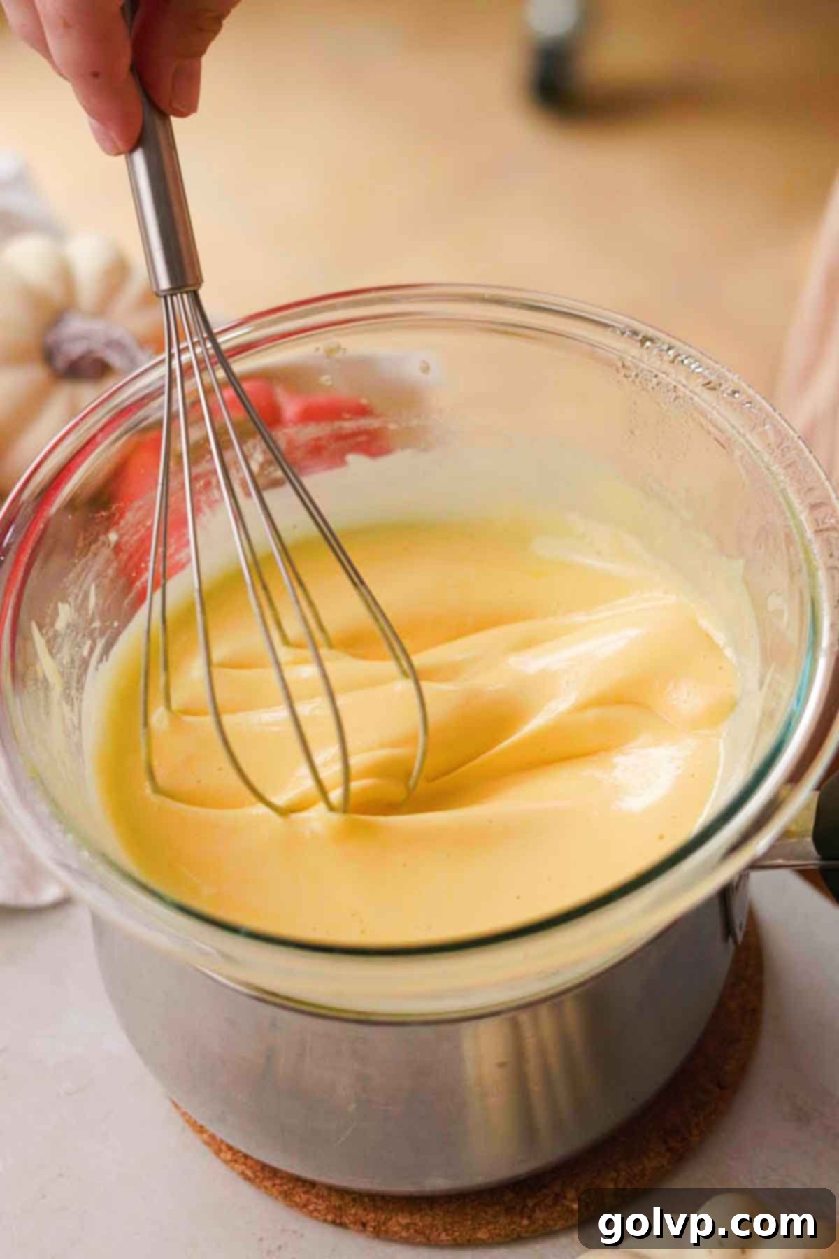 Cooking egg mixture over a saucepan for tiramisu base