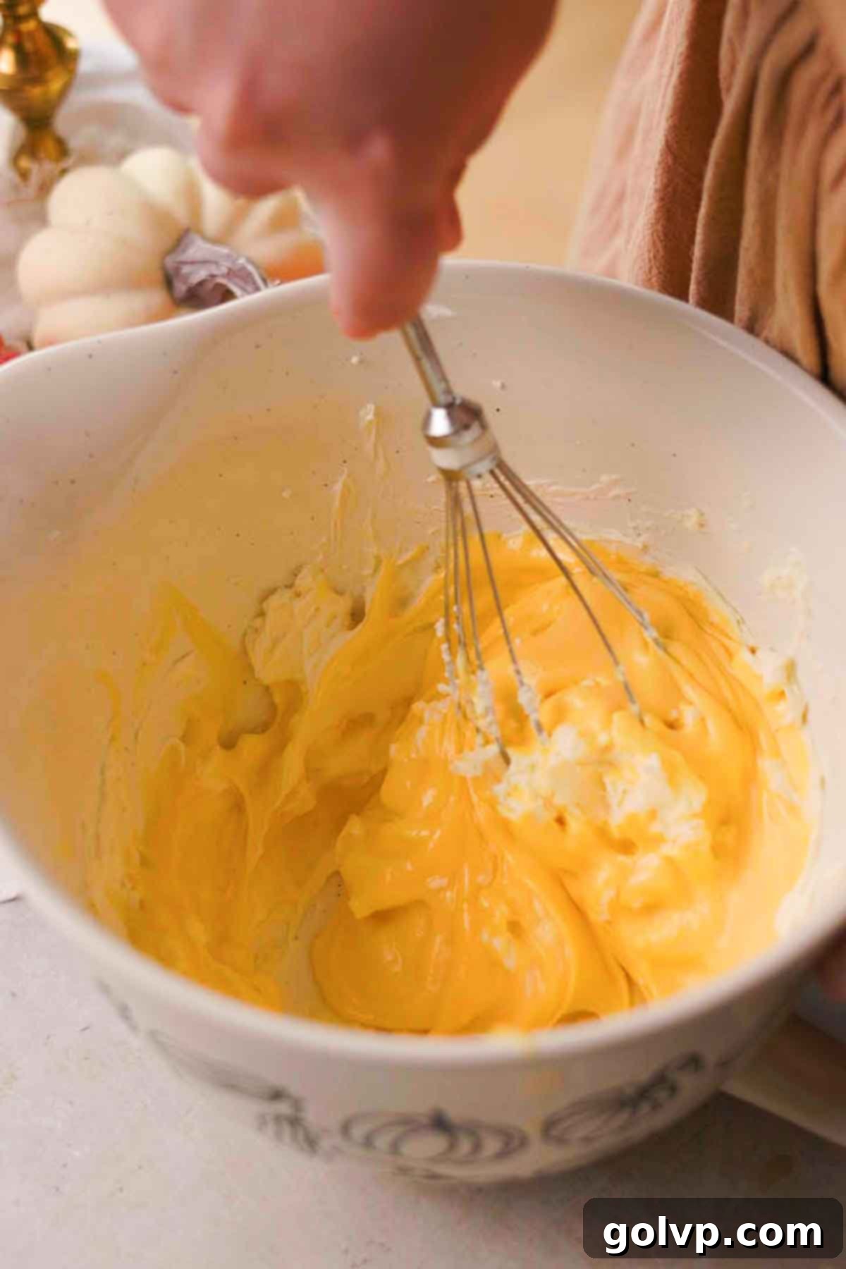 Mixing softened mascarpone cheese with the cooled egg mixture