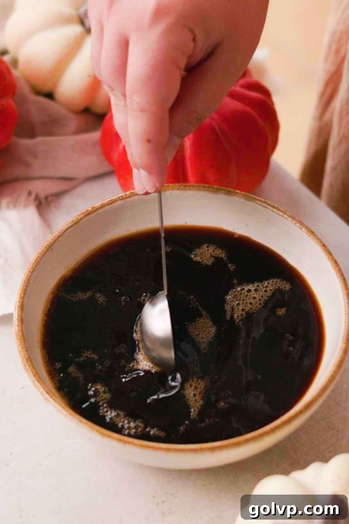 Mixing espresso, sugar, and pumpkin spice for ladyfinger soak