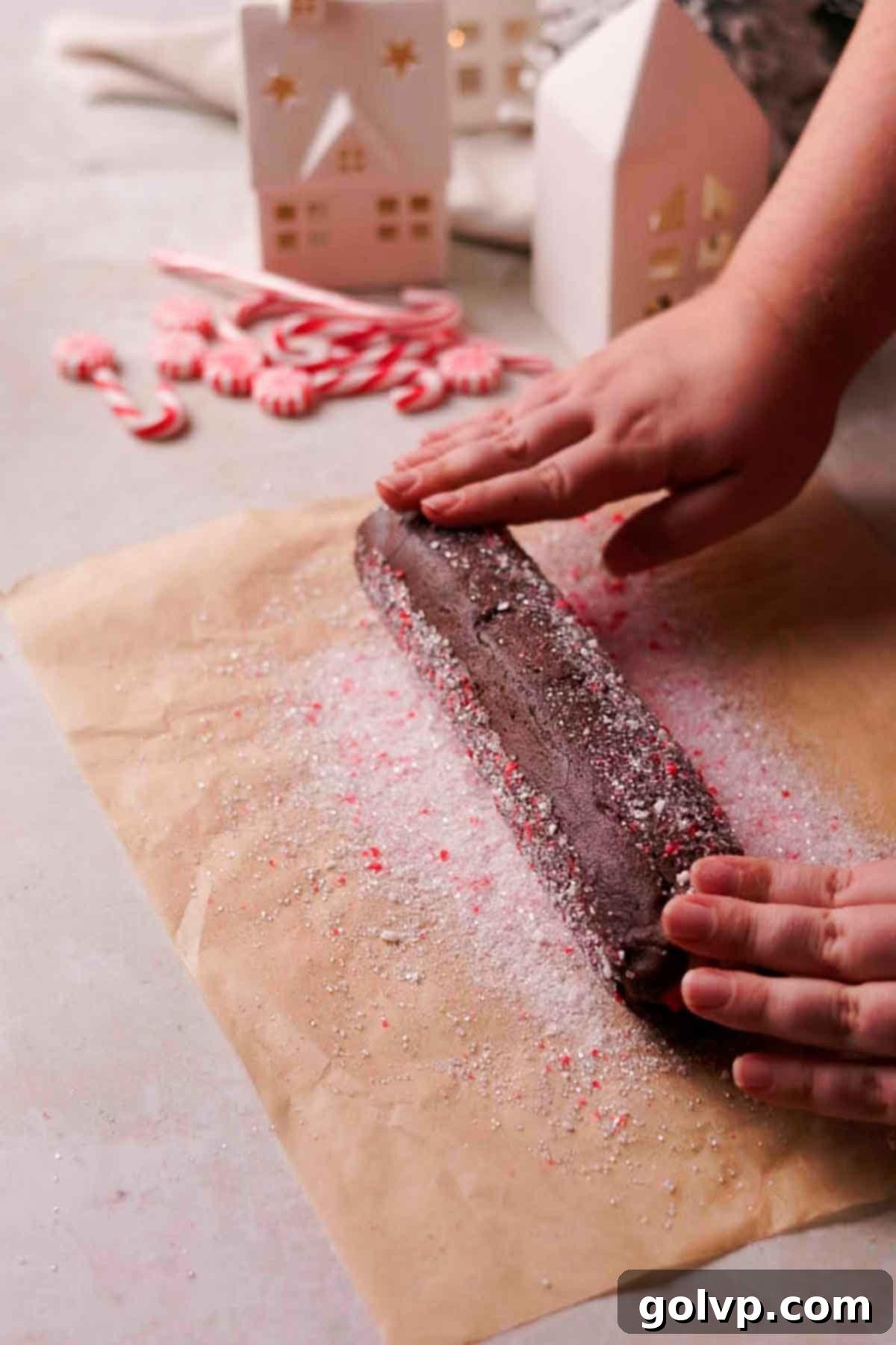 coating cookie dough log in peppermint sugar mixture