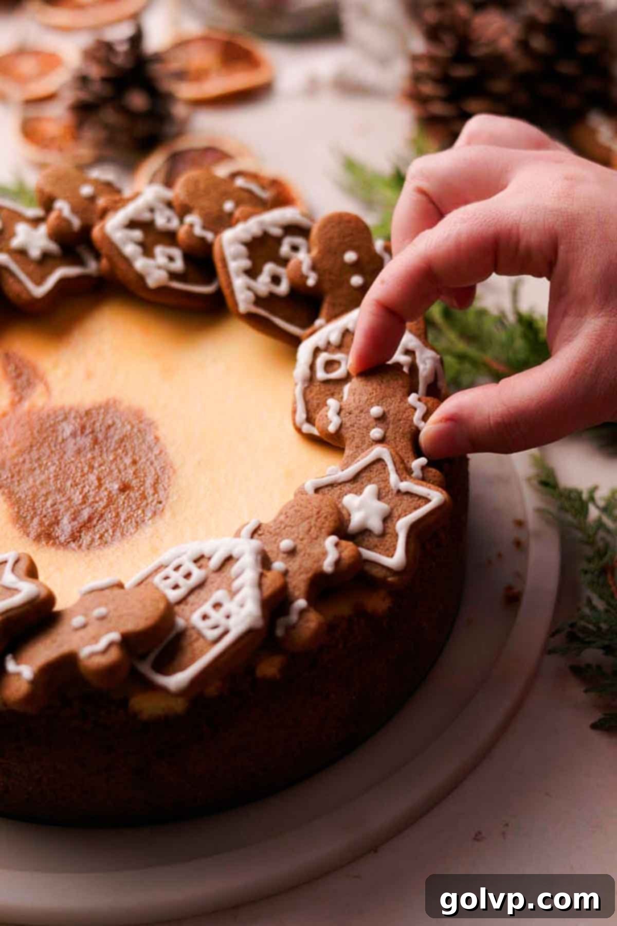 decorating the gingerbread cheesecake with gingerbread cookies