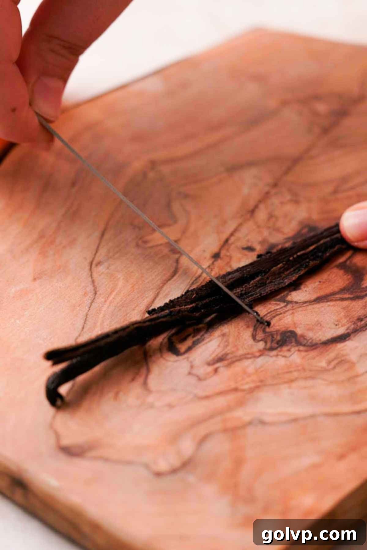 scraping out the seeds from a vanilla bean pod