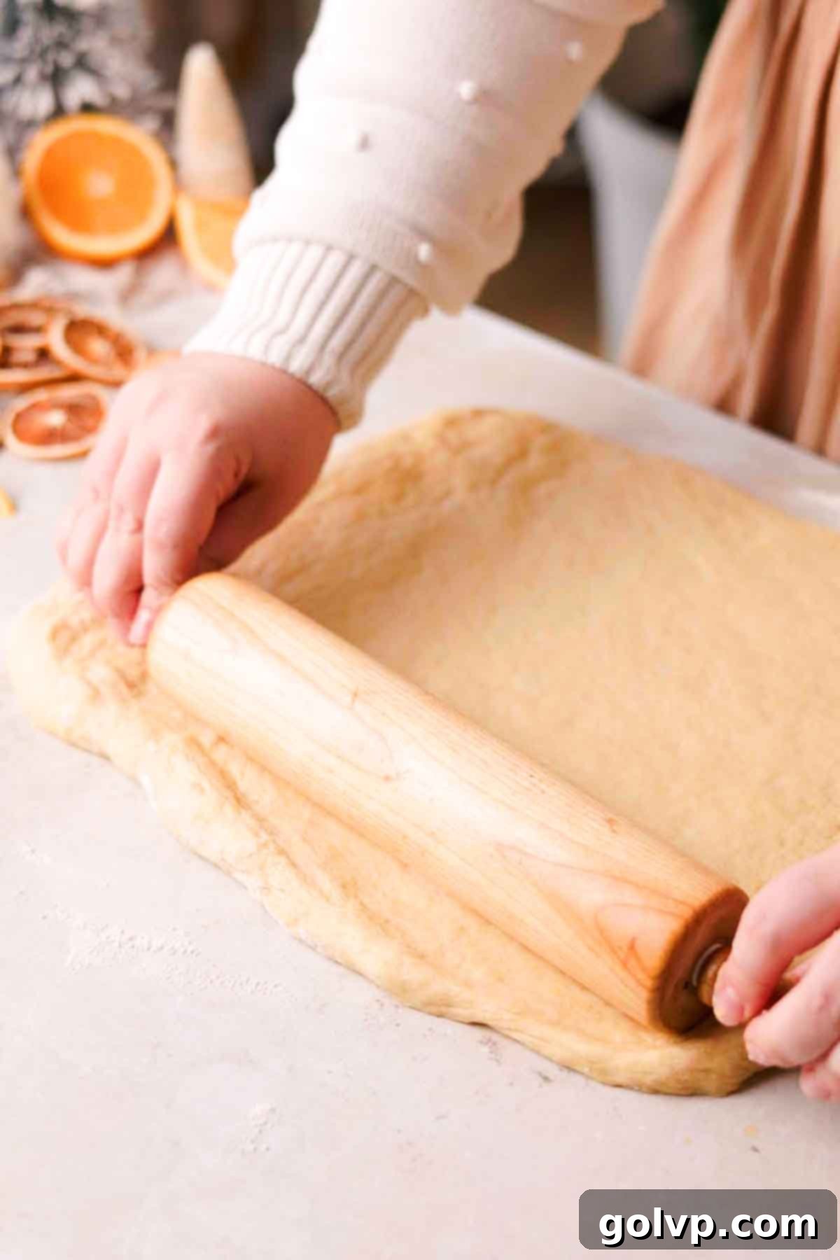 rolling out orange cinnamon roll dough
