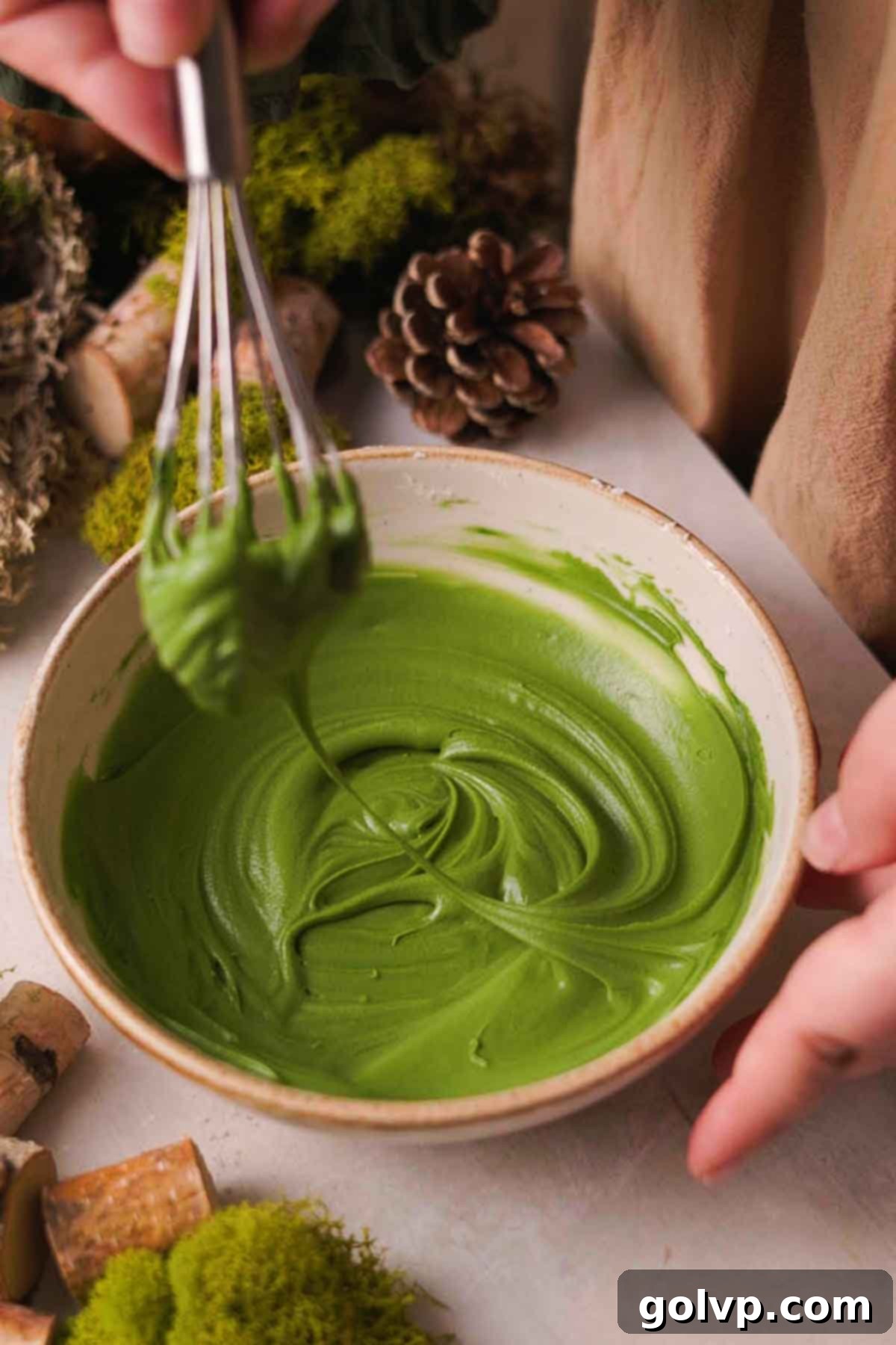 green colored frosting in a bowl for piping grass on cookies
