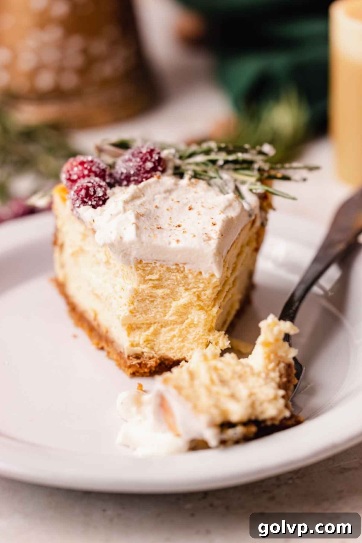 Decadent Holiday Eggnog Cheesecake 12 slice of eggnog cheesecake with fork