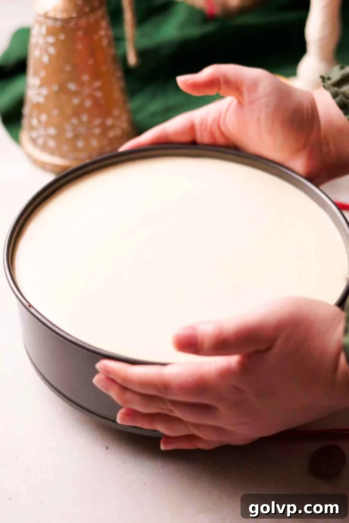 Decadent Holiday Eggnog Cheesecake 8 tapping unbaked cheesecake on counter