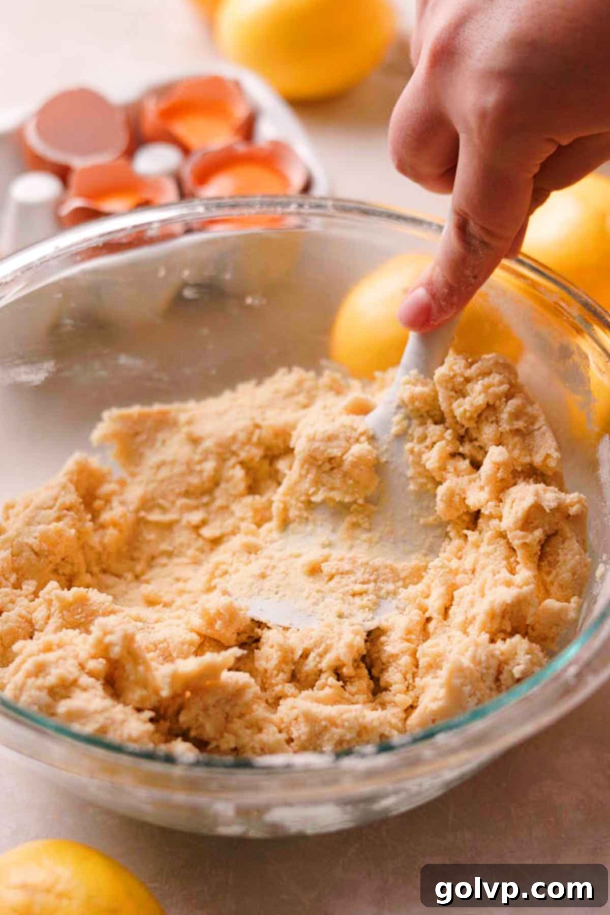 Folding together the shortbread cookie dough with a spatula in a mixing bowl until just combined