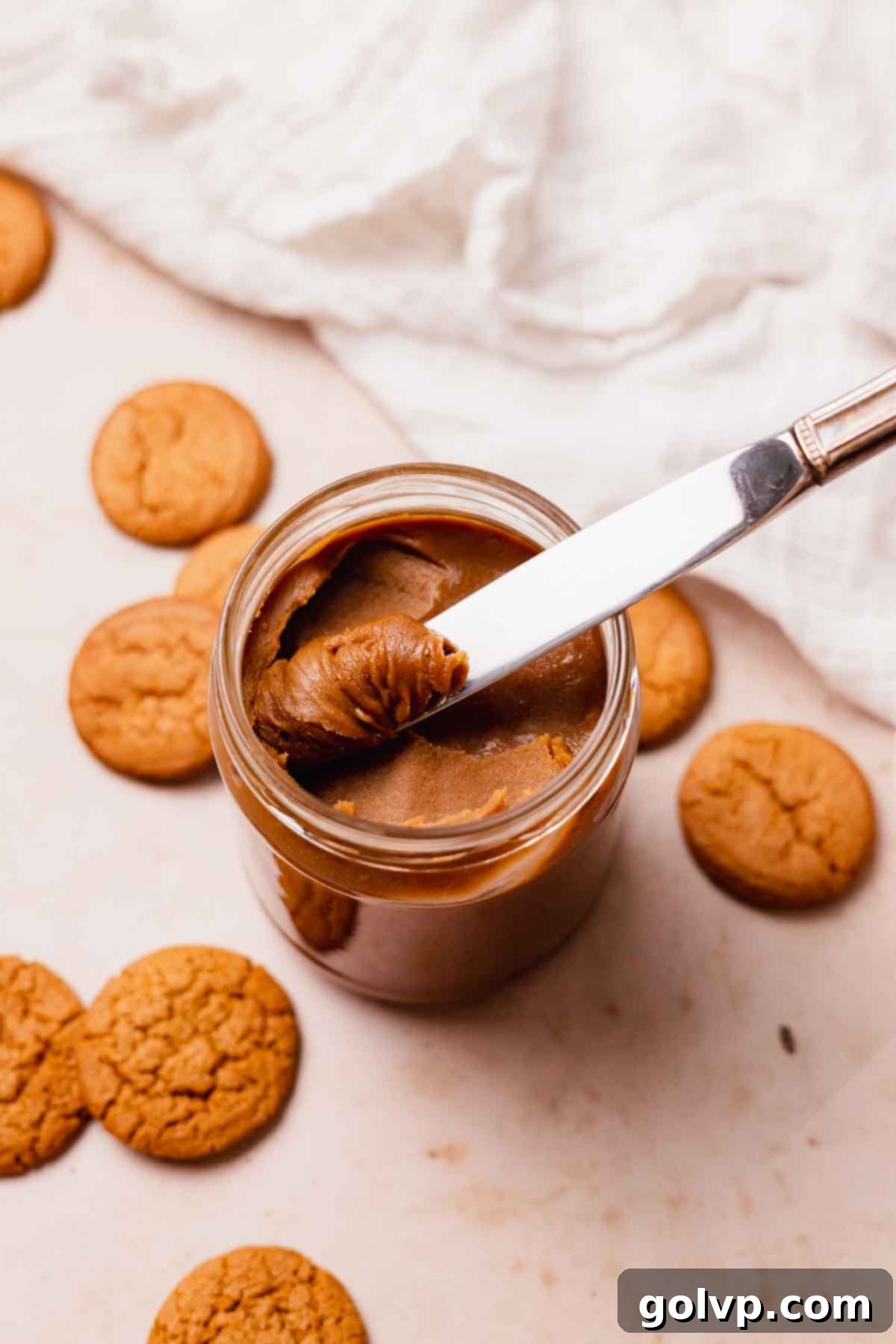 homemade creamy cookie butter spread in a jar with a knife