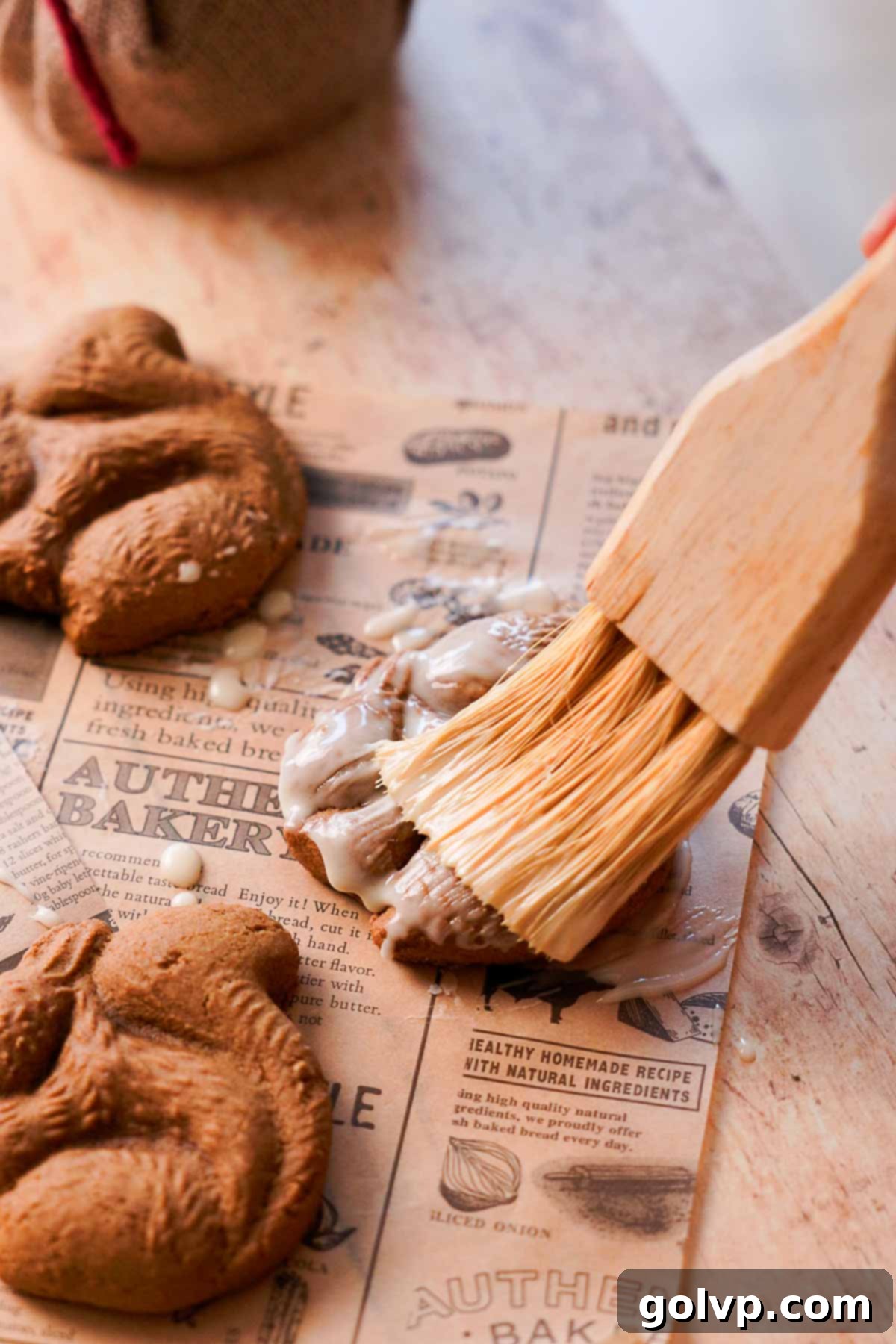 brushing orange glaze over squirrel shaped gingerbread cookie