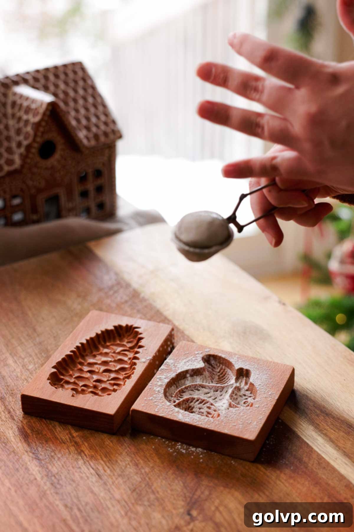 sifting flour over wooden cookie molds