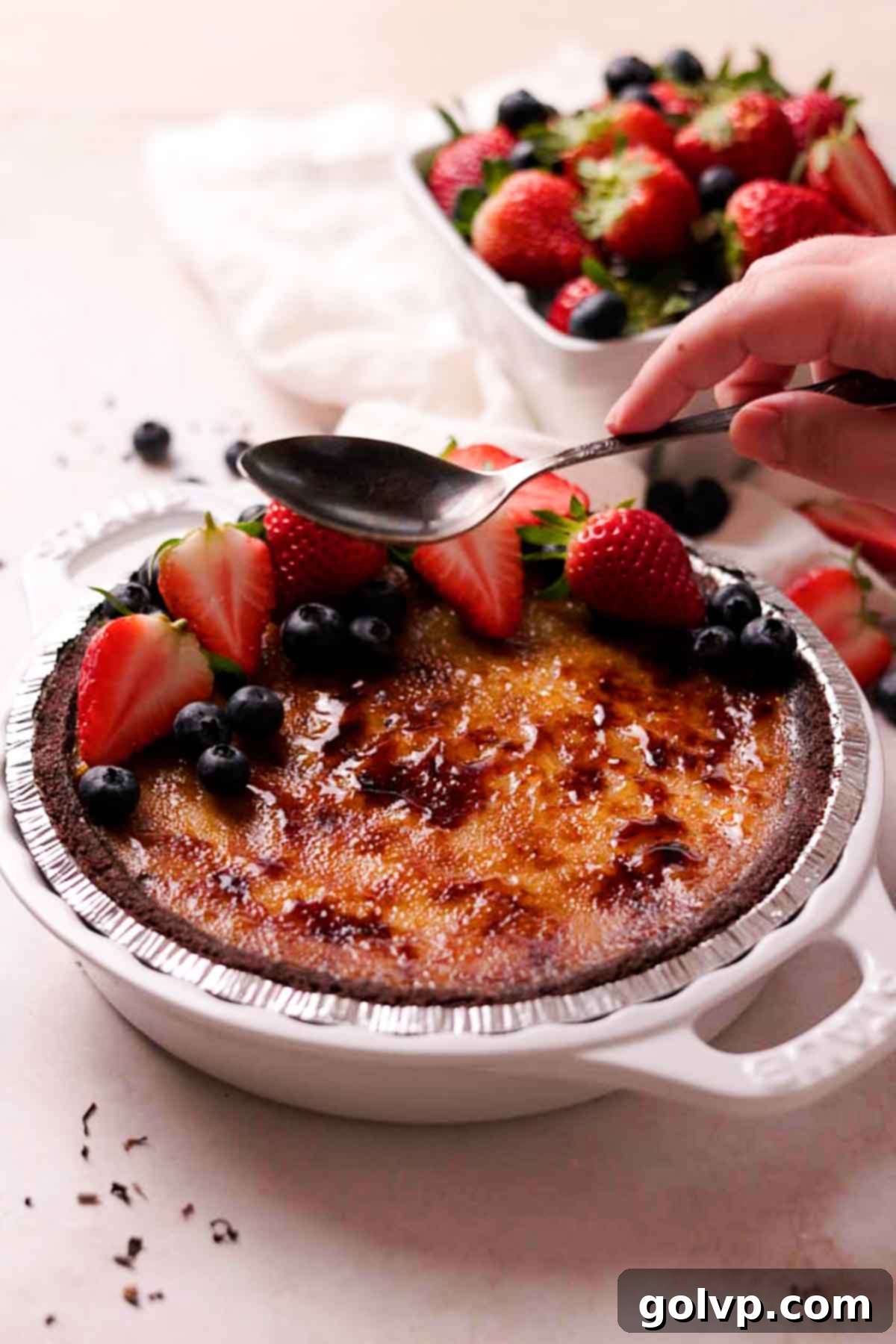 cracking the top of creme brulee pie with the back of a spoon